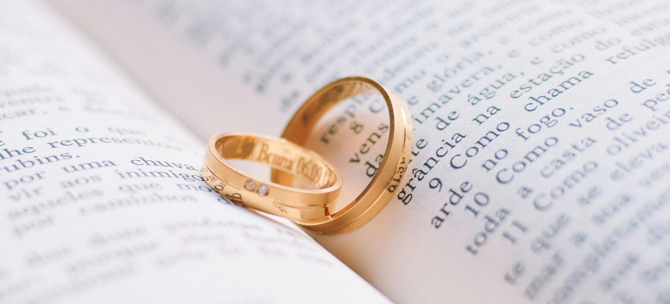 Gold wedding rings on an open book